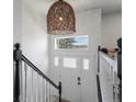 Staircase and foyer boasts modern light fixture and bright, fresh paint at 11165 W 58Th Ave, Arvada, CO 80002