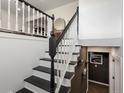 Contemporary staircase with black steps and white railings showing an open upstairs area at 11165 W 58Th Ave, Arvada, CO 80002