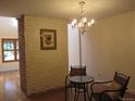 Cozy dining area with hardwood floors, a decorative brick wall, and an elegant chandelier at 7721 S Curtice Way # B, Littleton, CO 80120