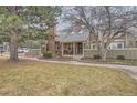 Inviting townhome with a well-maintained lawn, mature trees, and cozy front porch detail at 7721 S Curtice Way # B, Littleton, CO 80120