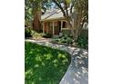 Charming brick home with a inviting front entrance and lush landscaping, featuring a 'For Sale' sign at 7721 S Curtice Way # B, Littleton, CO 80120