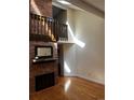 Bright living room featuring a brick fireplace, wooden floors, and natural light from high windows at 7721 S Curtice Way # B, Littleton, CO 80120