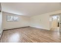 Open-concept living room with wood floors and an easy flow to the kitchen at 5995 W Hampden Ave # 2G, Denver, CO 80227