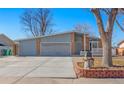 Single Gathering home with a two-car garage, brick facade, covered porch, and manicured flower beds at 1027 Norfolk St, Aurora, CO 80011