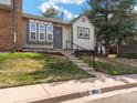 View of a well-maintained home with newly-laid lawn, gray siding, and steps leading to the front door at 16986 E Piedmont Dr # A, Aurora, CO 80015