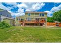 Spacious backyard with a large wooden deck, a lush lawn, and a storage shed at 2882 Signal Creek Dr, Thornton, CO 80241