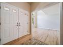 Welcoming foyer with light hardwood floors, double doors, and an open view to the living room at 2882 Signal Creek Dr, Thornton, CO 80241