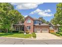 Inviting two-story brick home featuring a well-maintained lawn and convenient two-car garage at 6429 S Jamaica Cir, Englewood, CO 80111