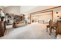 Spacious living room featuring a bookshelf, comfortable seating, and inviting ambiance at 15395 E Penwood Pl, Aurora, CO 80015