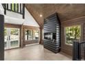 Bright living room with wooden walls, modern fireplace, and outdoor view from the double doors at 46 Silver Creek Rd, Idaho Springs, CO 80452