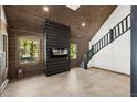Cozy living room featuring wood paneling, modern fireplace, and staircase to the second floor at 46 Silver Creek Rd, Idaho Springs, CO 80452