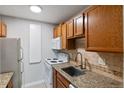 Charming kitchen featuring granite countertops, tile backsplash, and essential appliances at 5995 E Iliff-1 Ave # 309, Denver, CO 80222