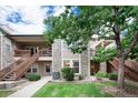 Charming two-story condo featuring stone accents, landscaped yard, wooden stairways, and ample natural light at 3952 S Carson St # 103, Aurora, CO 80014