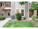 Close-up of a condo's exterior showing stone accents, manicured landscaping, and well-maintained walkways at 3952 S Carson St # 103, Aurora, CO 80014