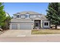 Attractive two-story home features stone accents, a three-car garage, and a well-manicured front yard at 598 Stonemont Dr, Castle Pines, CO 80108