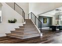 Elegant staircase with black metal railings and carpeted steps leading to a bright, open living space at 598 Stonemont Dr, Castle Pines, CO 80108