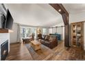 Cozy living room with fireplace, hardwood floors, and large windows offering scenic views at 2859 Cagle Dr, Larkspur, CO 80118