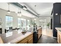 Open concept kitchen with stone countertops, views to dining, living and outdoor balcony at 2501 15Th St # 2C, Denver, CO 80211