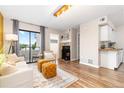 Open living area featuring a fireplace, a view to the patio, and a partial view to the kitchen at 1820 Newland Ct # 310, Lakewood, CO 80214
