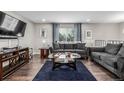 Comfortable living room with dark wood floors, plush furniture, and bright window lighting at 3134 S Fairplay St, Aurora, CO 80014