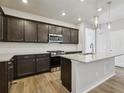 Well-equipped kitchen features stainless steel appliances, dark wood cabinets, and a large island at 7241 Goldbloom Ln, Littleton, CO 80125