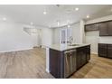 Open concept kitchen with stainless appliances, large island and hardwood flooring at 7241 Goldbloom Ln, Littleton, CO 80125