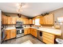 Efficient kitchen featuring stainless appliances, wood cabinets and tile backsplash at 43388 Somerset Ct, Elizabeth, CO 80107