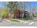 Corner view of the brick condominium building, showcasing its landscaping and architectural details at 534 E 7Th Ave # 107, Denver, CO 80203