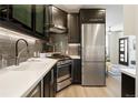Modern kitchen featuring stainless steel appliances and dark cabinetry at 1922 E 18Th Ave, Denver, CO 80206