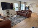 Inviting living room featuring a plush leather sofa, stylish rug, and bright natural light at 11832 Zenobia Loop, Westminster, CO 80031