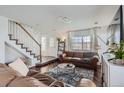 Cozy living room featuring a staircase, hardwood floors, and bright, natural light at 11832 Zenobia Loop, Westminster, CO 80031