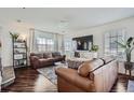 Inviting living room featuring hardwood floors, a modern entertainment center, and ample natural light at 11832 Zenobia Loop, Westminster, CO 80031