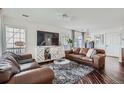 Spacious living room with hardwood floors, comfortable seating, and large windows with natural light at 11832 Zenobia Loop, Westminster, CO 80031