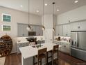 Modern kitchen with stainless steel appliances, gray cabinets, island with seating, and pendant lighting at 27110 E Fremont Pl, Aurora, CO 80016