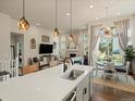 Open concept living space with a large kitchen island, fireplace, and bright dining area at 27110 E Fremont Pl, Aurora, CO 80016