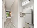 Bright kitchen features white cabinetry and appliances, seamlessly connecting to the living space at 8879 W Floyd Ave, Lakewood, CO 80227