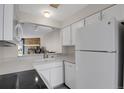 Bright kitchen with stainless steel appliances and a view into the living area with a fireplace at 8879 W Floyd Ave, Lakewood, CO 80227