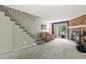 Living room featuring a stone fireplace, sliding glass doors, and access to the staircase at 8879 W Floyd Ave, Lakewood, CO 80227