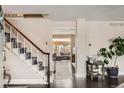Inviting foyer featuring a staircase with decorative carpet, hardwood floors, and an entry to the living room at 6494 W 85Th Ave, Arvada, CO 80003