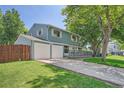 Attractive home with a two-car garage, blue siding, a front porch, and a manicured lawn at 6494 W 85Th Ave, Arvada, CO 80003