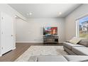 Bright living room with hardwood floors, a plush gray sofa, and a large flat-screen TV for entertainment at 42741 Ivydel Cir, Elizabeth, CO 80107