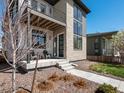 Modern two-story home with balcony and stone facade, featuring a landscaped front yard at 6054 N Perth St, Aurora, CO 80019