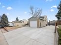 A house with a large driveway leading to an attached two-car garage, and side yard with wood fence at 4182 S Bahama St, Aurora, CO 80013