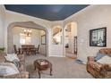 Inviting living room with stone archways and a view into the dining area at 5855 Saddle Creek Trl, Parker, CO 80134