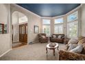 Comfortable living room featuring large windows with plantation shutters and warm decor at 5855 Saddle Creek Trl, Parker, CO 80134