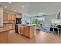 Bright, open kitchen with wood cabinets, a kitchen island, and seamless flow to the living area at 612 Blue Teal Dr, Castle Rock, CO 80104