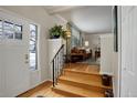 Inviting foyer with hardwood floors, stairs, and an open view to the living room with stylish decor at 7835 Nelson St, Arvada, CO 80005