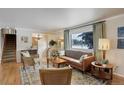 Bright living room featuring hardwood floors, a large window, and comfortable seating at 7835 Nelson St, Arvada, CO 80005