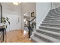 Inviting foyer with gleaming hardwood floors, a grand staircase, and elegant front doors at 7472 S Utica St, Littleton, CO 80128