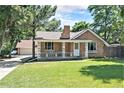 Charming brick home with a lush front lawn and a welcoming porch, perfect for relaxing outdoors at 11940 W Independence Ave, Lakewood, CO 80401